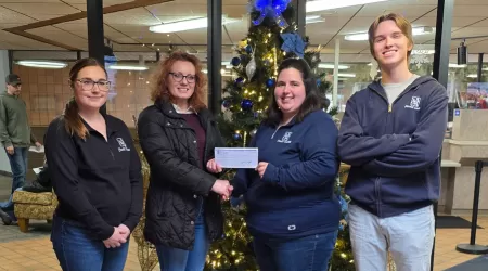 AAACU Team member presents a check to a member of the Cheboygan High School Senior Class of 2025